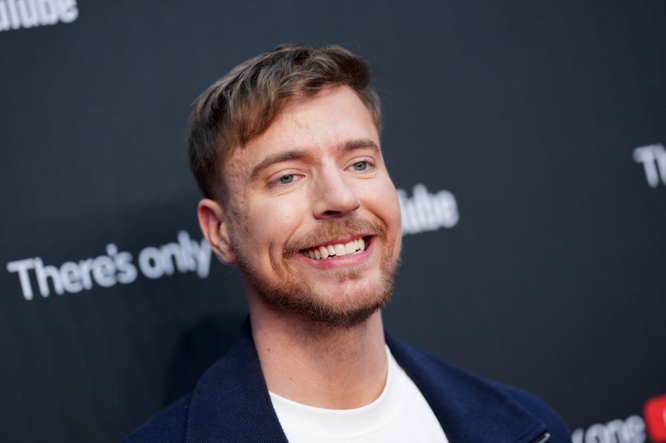 Man in blue blazer and white shirt poses on red carpet