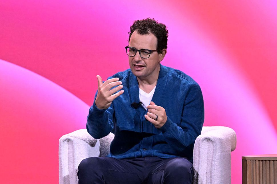 Dario Amodei sitting in a chair on a stage.