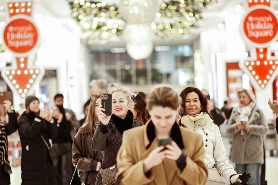Shoppers walking into a Macy's store.