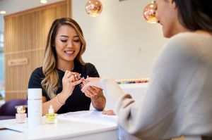 A MiniLuxe nail technician files a client's nails